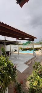 une terrasse avec un pavillon et une piscine dans l'établissement Casa de Praia - Francês/Marechal Deodoro, à Marechal Deodoro