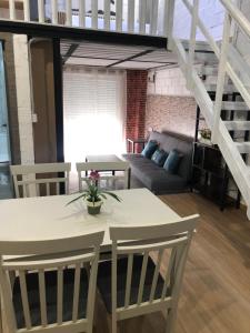 - un salon avec une table, des chaises et un canapé dans l'établissement Loft 2 , San Ignacio Maracena, à Maracena