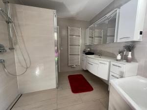 a bathroom with a shower and a red rug at Ferienhaus Nicole II, Barrierefrei, mit HIRO Lift in Quedlinburg +54 photos