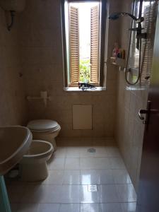 a bathroom with a toilet and a sink and a window at B&B Fronte mare in Belmonte Calabro