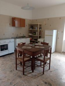 een keuken met een tafel en stoelen en een koelkast bij B&B Fronte mare in Belmonte Calabro