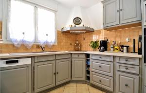 a kitchen with white cabinets and a sink at Awesome Home In Slaurent-La-Vernede in Fontarèches