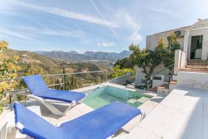 patio z 2 krzesłami i basenem w obiekcie Cortijo Mandala Nerja w mieście Nerja