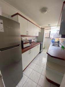 a kitchen with a refrigerator and a sink in it at En Iquique, Chile, depto diario frente a playa Brava in Iquique