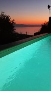 a swimming pool with the sunset in the background at Villa Verde in Cefalù