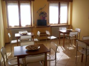 a dining room with tables and chairs and windows at Hotel Rosalpina in Serina