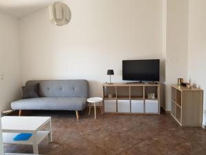 ein Wohnzimmer mit einem blauen Sofa und einem TV in der Unterkunft Vila Mila Apartments in Sukošan