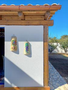 Una pared blanca con dos bolsas. en Villa Nica, en Granitola