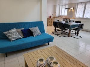 ein Wohnzimmer mit einem blauen Sofa und einem Tisch in der Unterkunft Loft 3 du Temple pour 4 pers & Parking in Cambrai