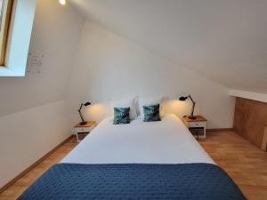 ein Schlafzimmer mit einem großen Bett mit blauer Bettwäsche und zwei Lampen in der Unterkunft Loft 3 du Temple pour 4 pers & Parking in Cambrai