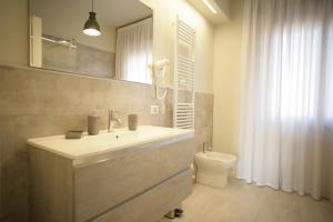uma casa de banho com um lavatório e um WC em Melograno Rooms B&B em Brogliano