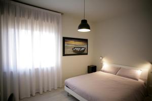 um quarto com uma cama e uma grande janela em Melograno Rooms B&B em Brogliano