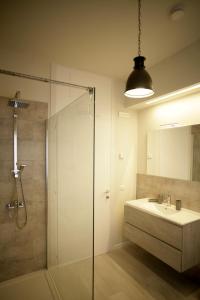 uma casa de banho com uma cabina de duche em vidro e um lavatório. em Melograno Rooms B&B em Brogliano