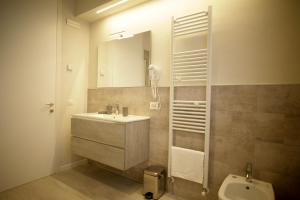 uma casa de banho com um lavatório, um espelho e um WC. em Melograno Rooms B&B em Brogliano