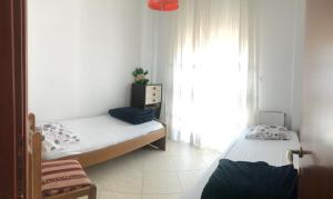 - une chambre avec 2 lits et une fenêtre dans l'établissement Apartment with two bedrooms in City Centre in Drama Greece, à Dráma