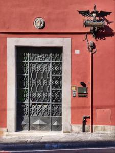 a red building with a door with a metal gate at B&B "La Bottega d'Arte" in Carrara