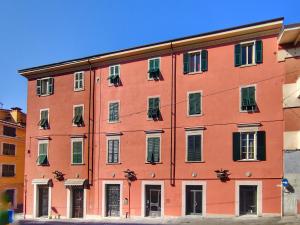 un grande edificio arancione con finestre su strada di B&B "La Bottega d'Arte" a Carrara