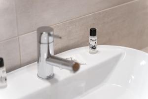 a bathroom sink with a faucet and a bottle of toothpaste at Quinta das Andorinhas in Carvoeiro
