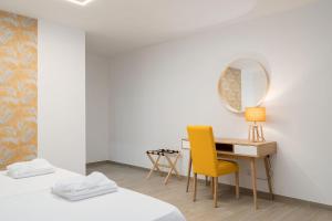 a bedroom with a desk and a chair and a mirror at Quinta das Andorinhas in Carvoeiro