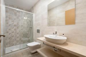 a bathroom with a sink and a toilet and a shower at Quinta das Andorinhas in Carvoeiro