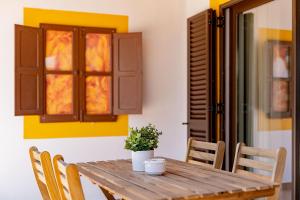 a wooden table with chairs and a potted plant on it at Quinta das Andorinhas in Carvoeiro