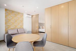 a living room with a table and chairs and a couch at Quinta das Andorinhas in Carvoeiro