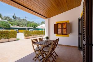 a wooden table and chairs on a patio at Quinta das Andorinhas in Carvoeiro