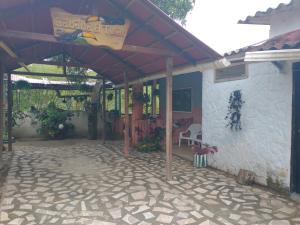 a patio of a house with awning and a chair at Cabaña El Tucan in Minca