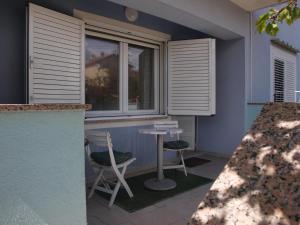 a patio with two chairs and a table and a window at Apartmani Luce in Zadar