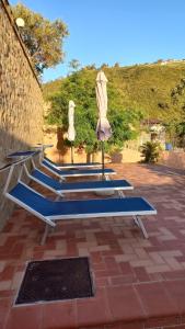 a row of benches with an umbrellas and sidx sidx at Villa Verde in Cefalù