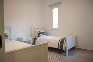 1 dormitorio con 2 camas y ventana en Luzzu - Family Friendly Maisonette en Xlendi