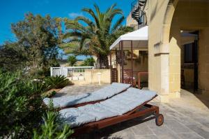 a bed sitting on the side of a house at Luzzu - Family Friendly Maisonette in Xlendi