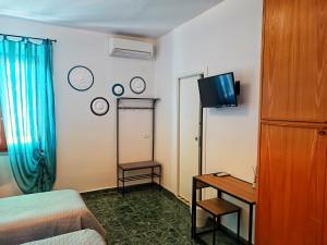 a hotel room with a bed and a desk and a television at Lo Zizzolo- Bed&Breakfast in Marina di Campo