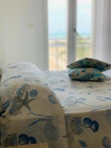 Una cama con una almohada y una estrella de mar. en Panorama Belvedere en Margherita di Savoia