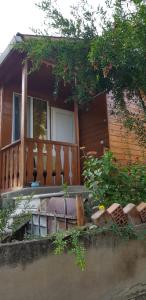 a house with a wooden porch with a fence at Wooden Cottages - Mtskheta in Mtskheta