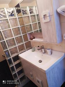 a bathroom with a sink and a mirror at Sea waves apartments in Nea Epidavros