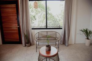 a room with a table and a chair and a window at Hostal Del Jaguar in Tulum