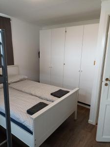 a bedroom with a white bed and white cabinets at FeelHome 2 bedrooms apartment Vidarsveg in Tromsø
