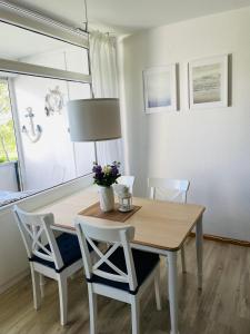 a dining room table with two chairs and a lamp at Ostseenest - Sonnige Ferienwohnung mit Ostseeblick in Heringsdorf