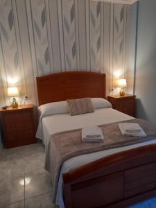 ein Schlafzimmer mit einem Bett mit zwei Nachttischen und zwei Lampen in der Unterkunft Casa ceferino in Barreiros