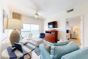 una sala de estar con un sofá y una mesa en Tradewind 1204, en Orange Beach