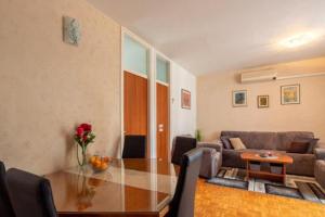 un soggiorno con tavolo in vetro e divano di Boka Apartment a Solin (Salona)
