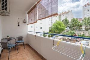 a balcony with a table and chairs and a window at Boka Apartment in Solin