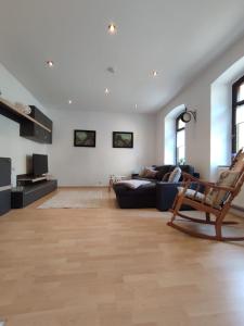 a living room with a couch and a chair at Ferienwohnung am Rabenauer Grund in Freital