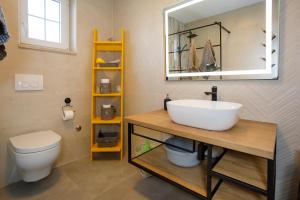 ein Badezimmer mit Waschbecken, Toilette und Spiegel in der Unterkunft New&Modern apartment Dora in Vrh + 42 Fotos