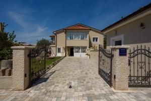 ein Haus mit einem Tor und einer Einfahrt in der Unterkunft New&Modern apartment Dora in Vrh