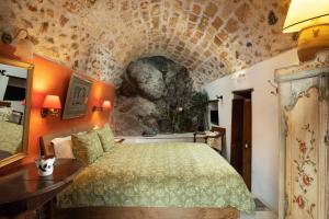 a bedroom with a bed and a stone wall at Dorovinis Monemvasia Castlehouses in Monemvasia