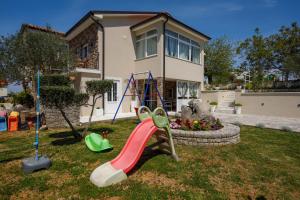 um parque infantil em frente a uma casa com escorrega em New&Modern apartment Dora em Vrh
