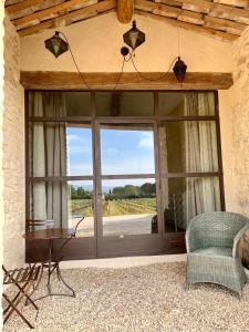 Zimmer mit einer großen Glastür mit einem Tisch und einem Stuhl in der Unterkunft La Verrière à Bonnieux in Bonnieux