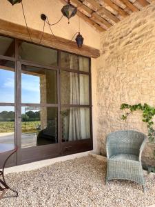 a room with a large glass door and a chair at La Verrière à Bonnieux in Bonnieux